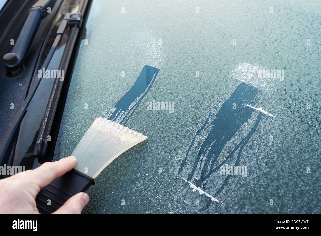 frosted car glass. Frosty patterns on a car windscreen . scraper for