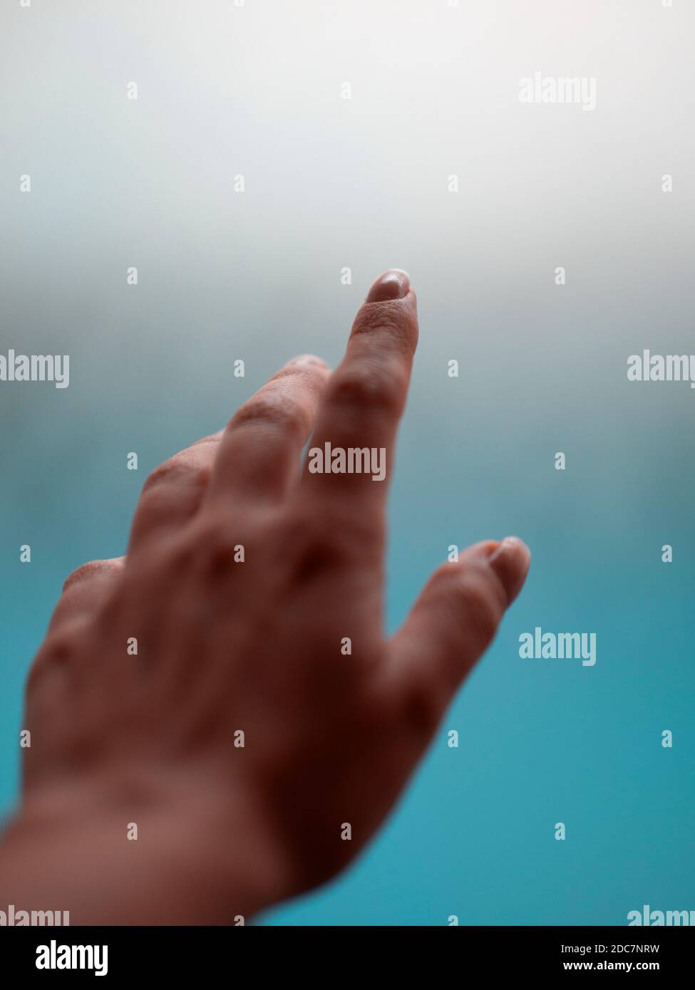 Woman's hand reaching toward a foggy background Stock Photo
