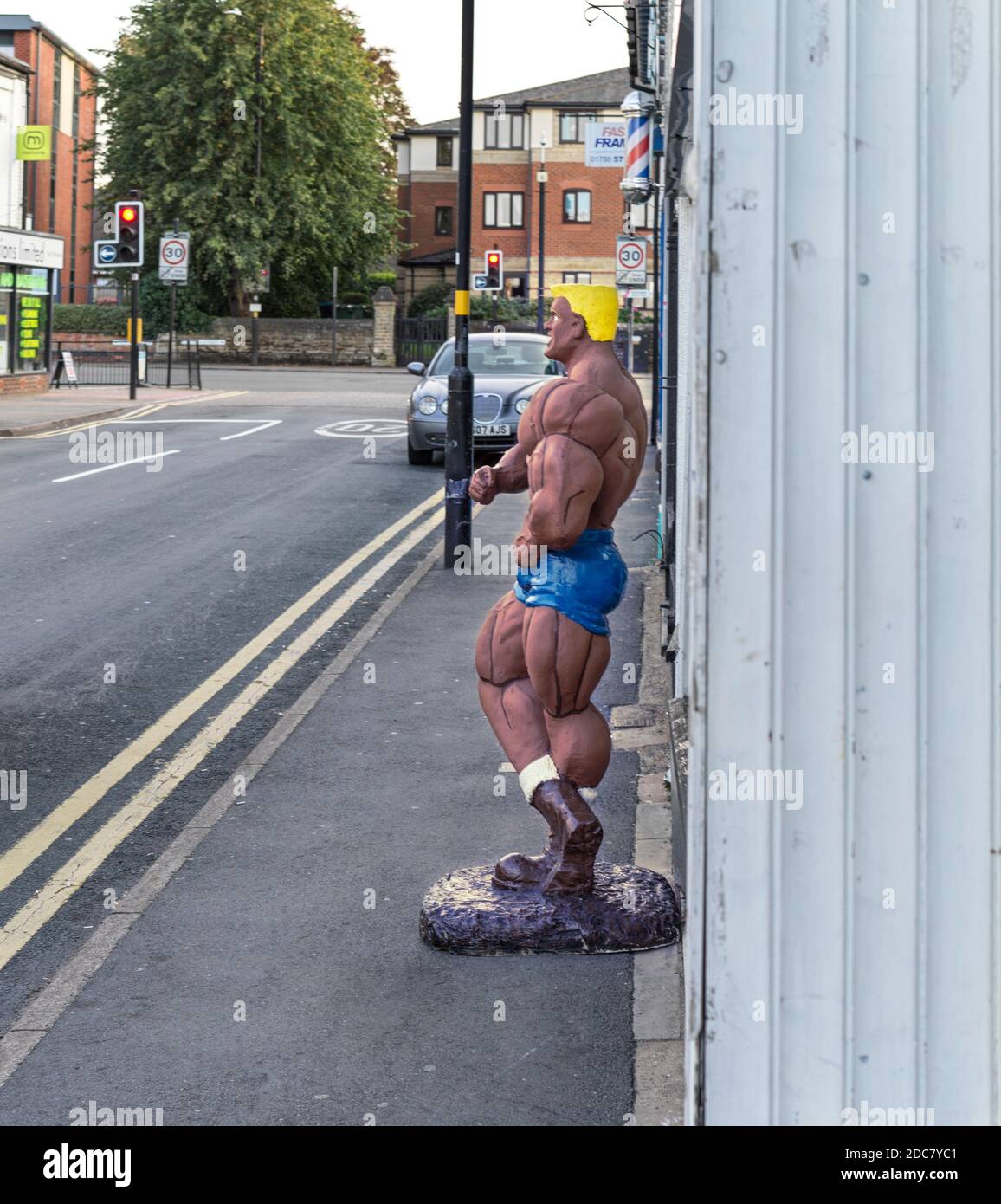 Figure outside a body building products shop in Rugby Stock Photo
