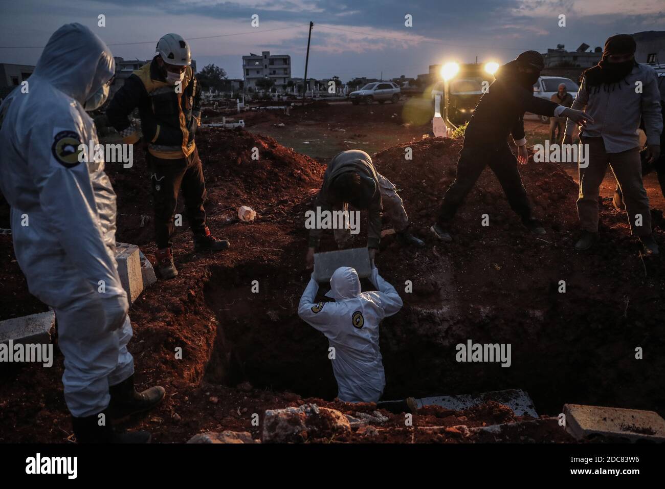 Idlib City, Syria. 19th Nov, 2020. Specialized members of the Syrian Civil Defence, also known as the White Helmets, bury a man who died as a result of contracting COVID-19, amid a spike in the number of coronavirus-related deaths in north-western Syria. Credit: Anas Alkharboutli/dpa/Alamy Live News Stock Photo