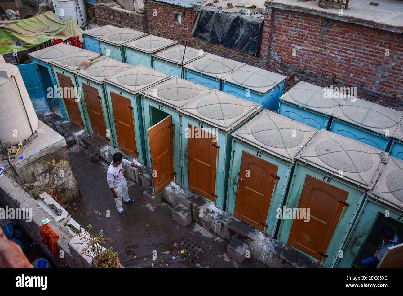 A man standing near the public toilets in Slum colony during the