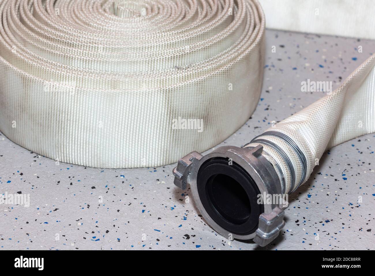 new fire hose, on the floor of the fire station. Stock Photo
