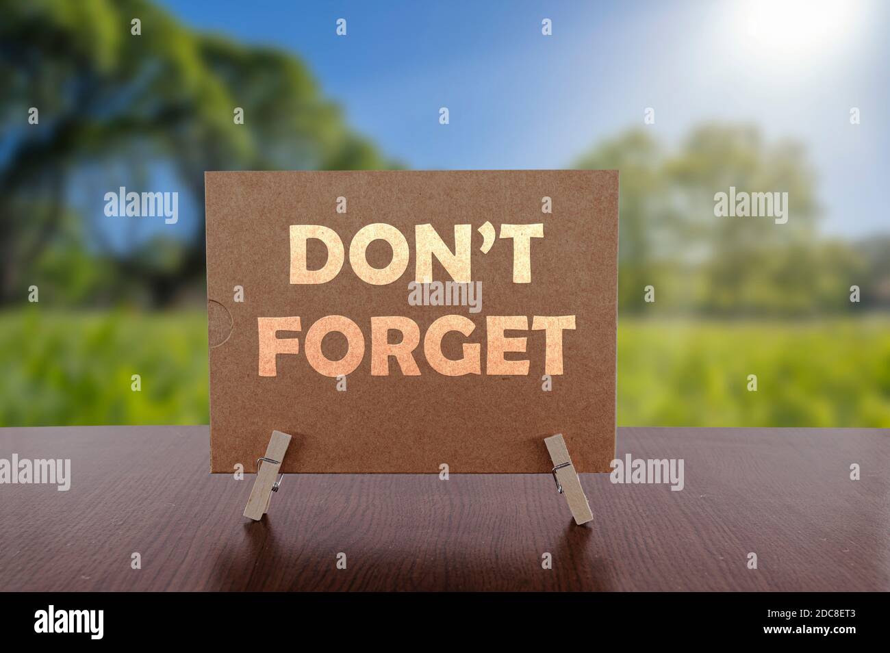 Don't forget card on the table with sunny green forest background. Stock Photo