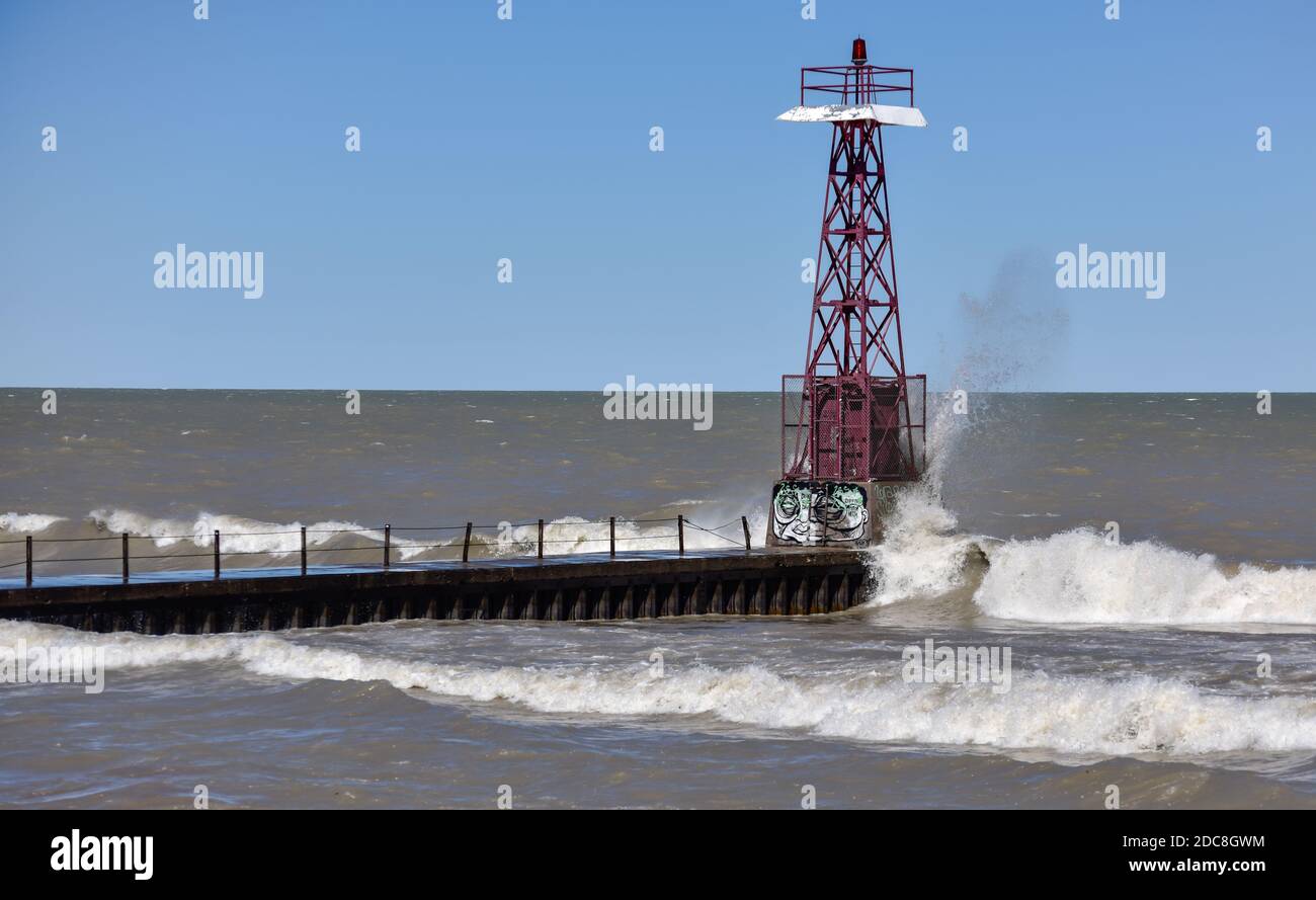 crashing waves splashing against the concrete lake pier in Spring Stock Photo