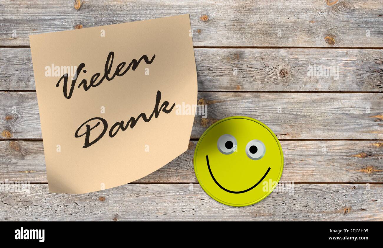 Sticky notes saying"Vielen Dank", translated "Thank you very much" and an emoji with a laughing face Stock Photo