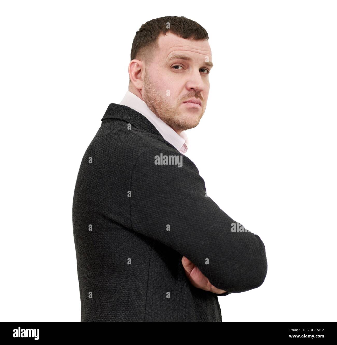 Side view of elegant young businessman standing with arms crossed ...