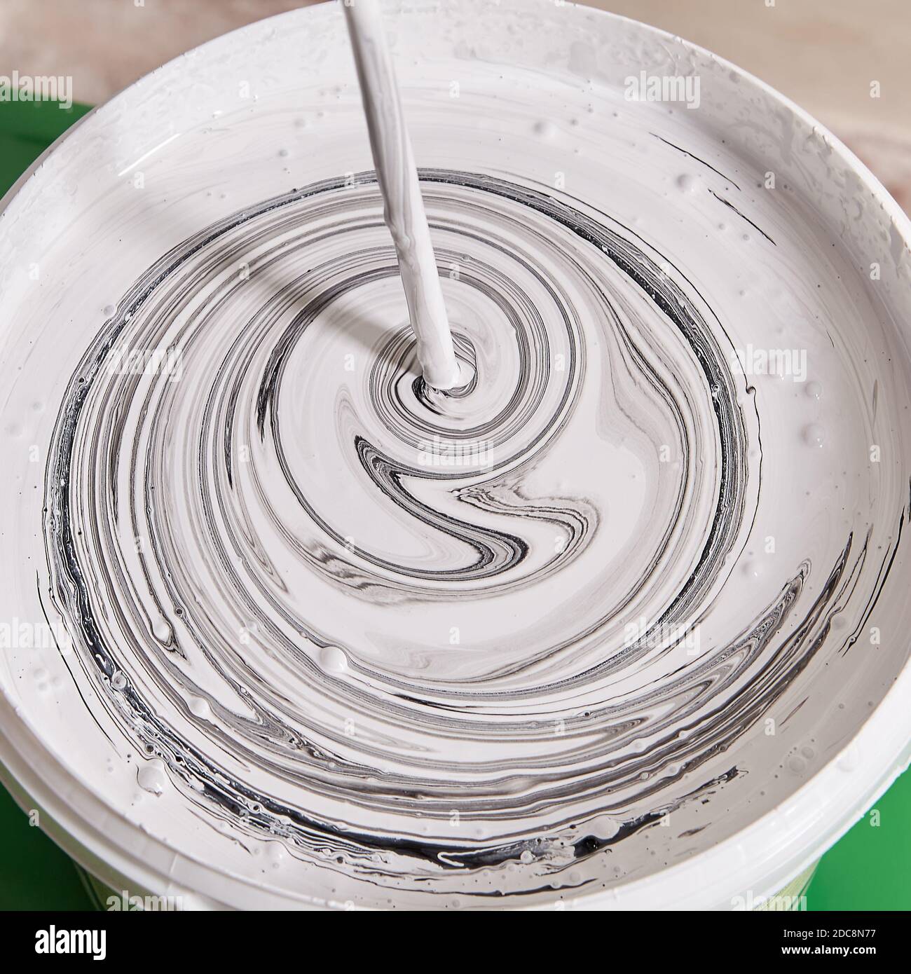 Making new color in the basket with help of mixer. House painter is