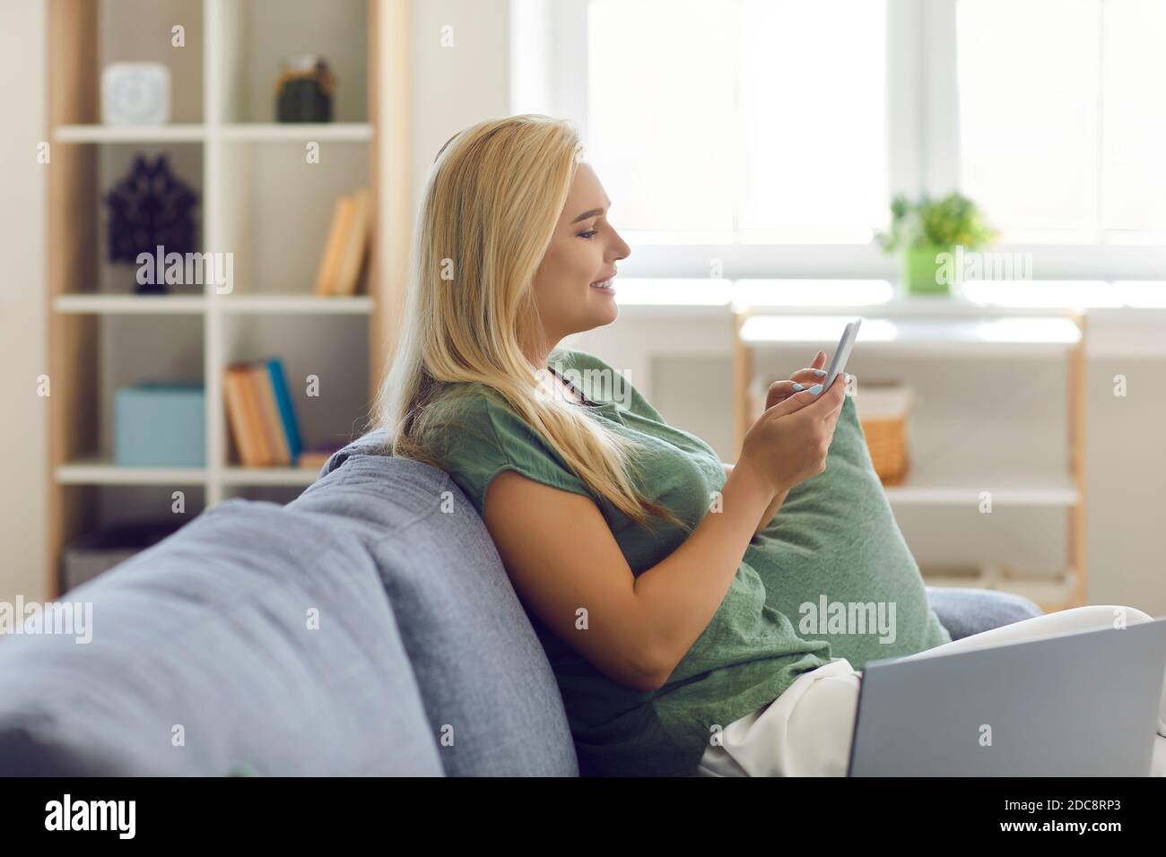 Young smiling blonde woman office worker sitting in office with notebook and pen Stock Photo
