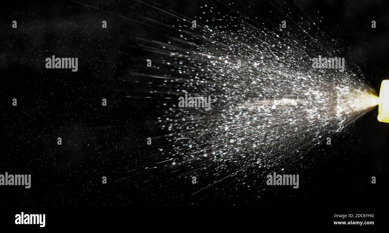 closeup view of liquid spray mist shooting out from spray bottle Stock