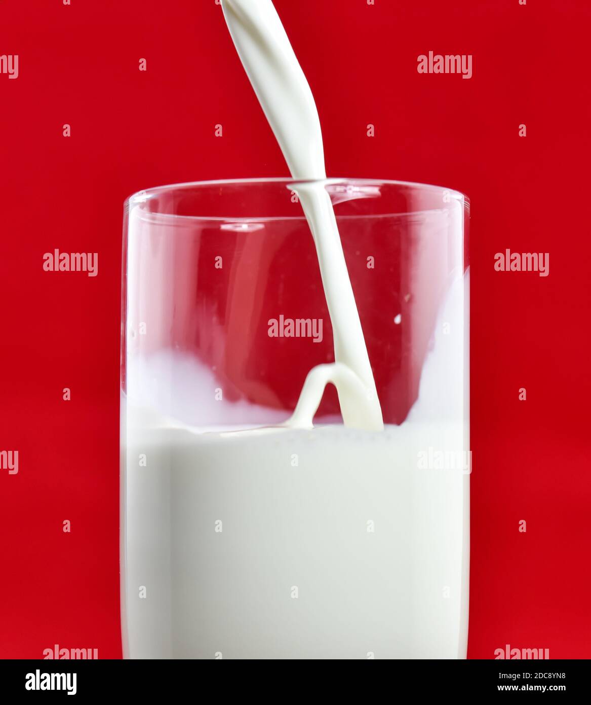 Pouring white milk into clear glass Stock Photo Alamy