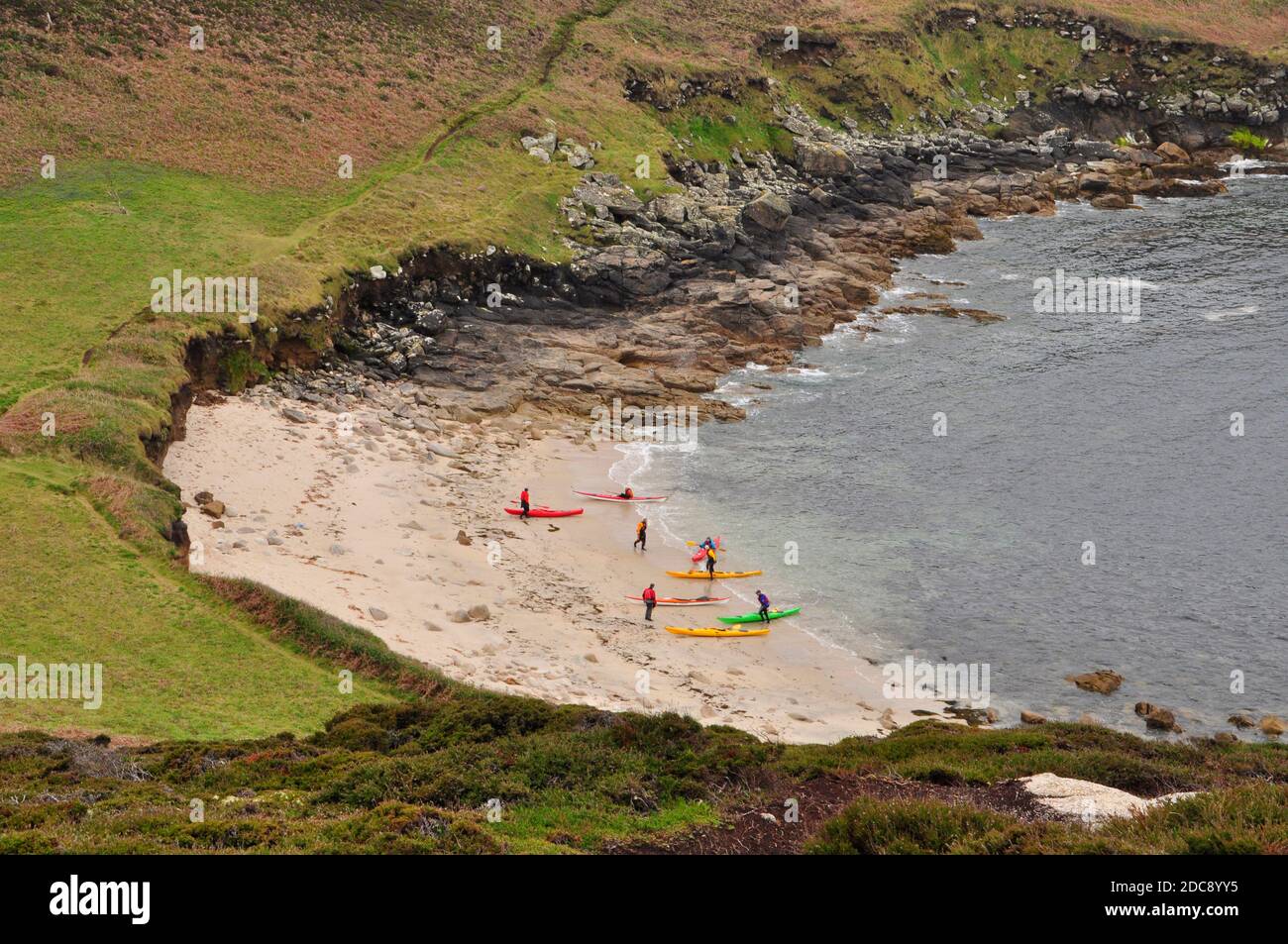 A group of canoeists rest on the beach in Bread and Cheese Cove below the Day mark on the island of St Martin's in the Isles of Scilly, Cornwall.UK Stock Photo