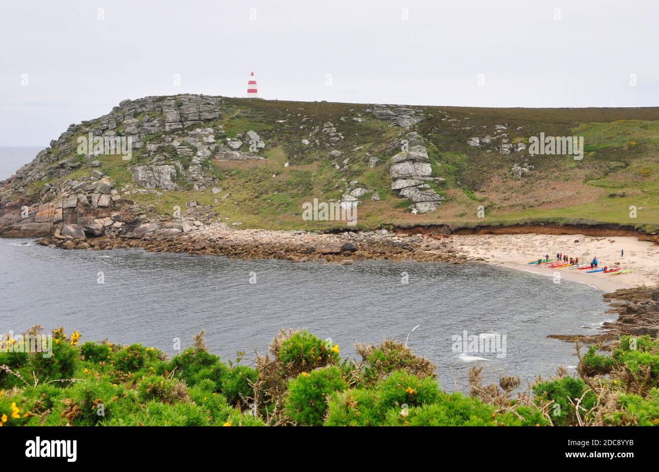 a group of canoeists rest on the beach in Bread and Cheese Cove below the Day mark on the island of St Martin's in the Isles of Scilly, Cornwall.UK Stock Photo