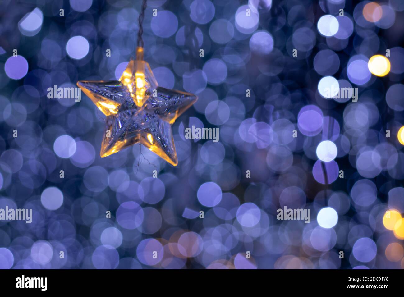 Rain of bokeh lights and a star shaped ornament with a dark bluish background Stock Photo
