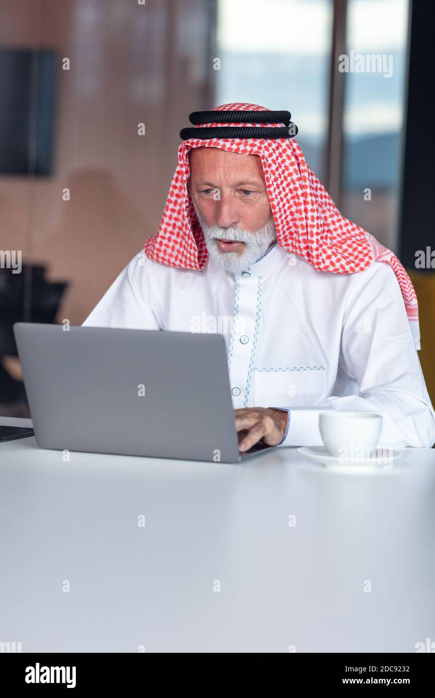Arab businessman looks surprised while using a laptop Stock Photo