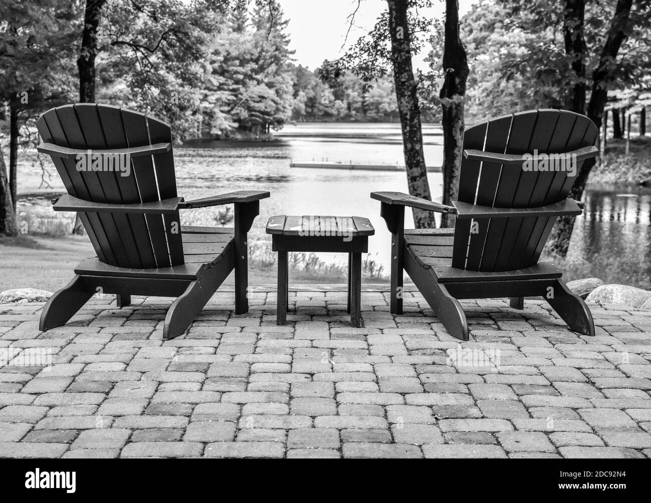 Empty Adirondack lawn chairs along the shore Stock Photo