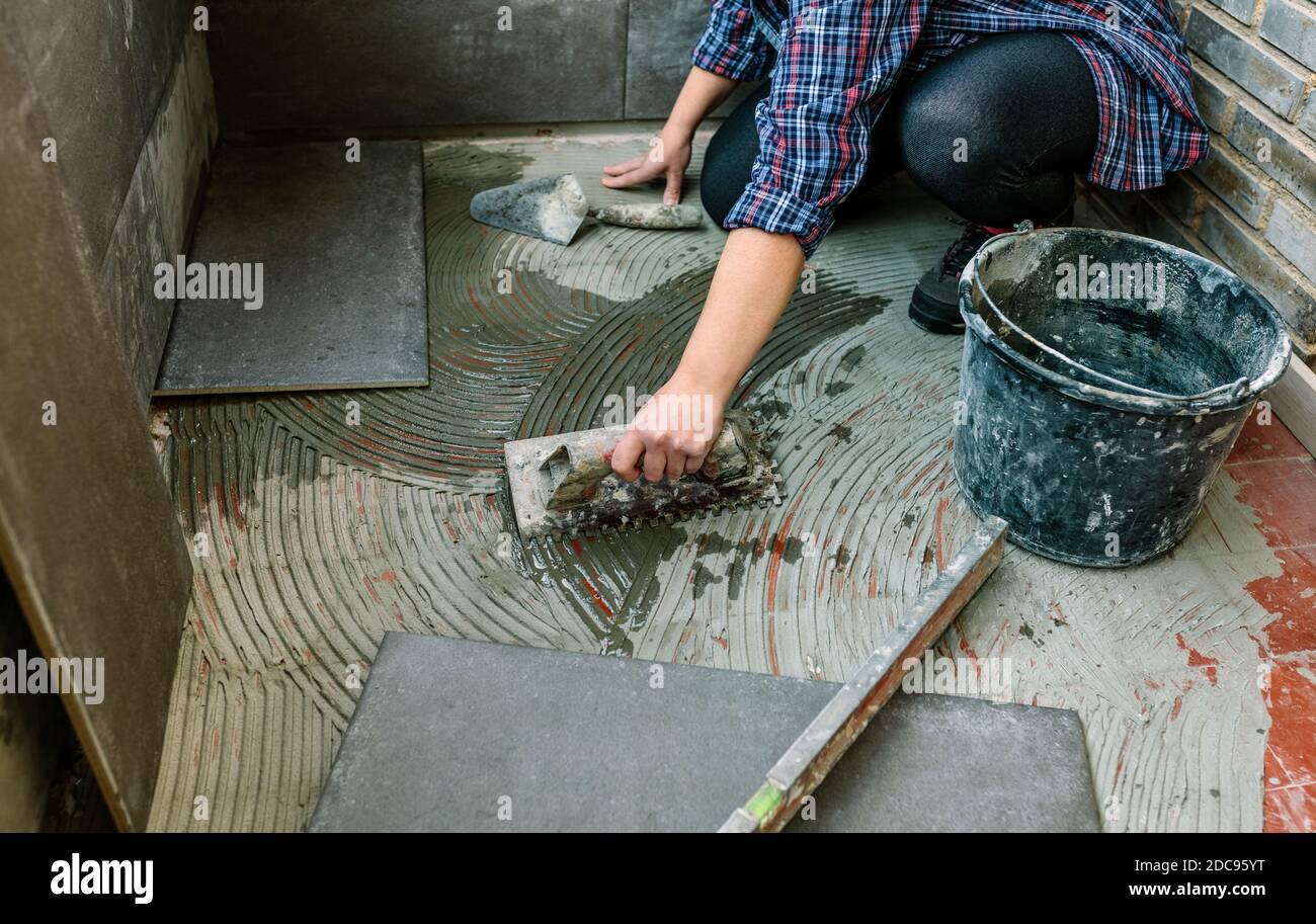 Female mason laying tiles on a terrace Stock Photo Alamy