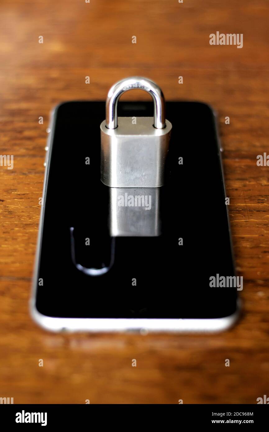 Cell phone with a closed padlock that is reflected on the screen like an open padlock. Security and vulnerability concept Stock Photo