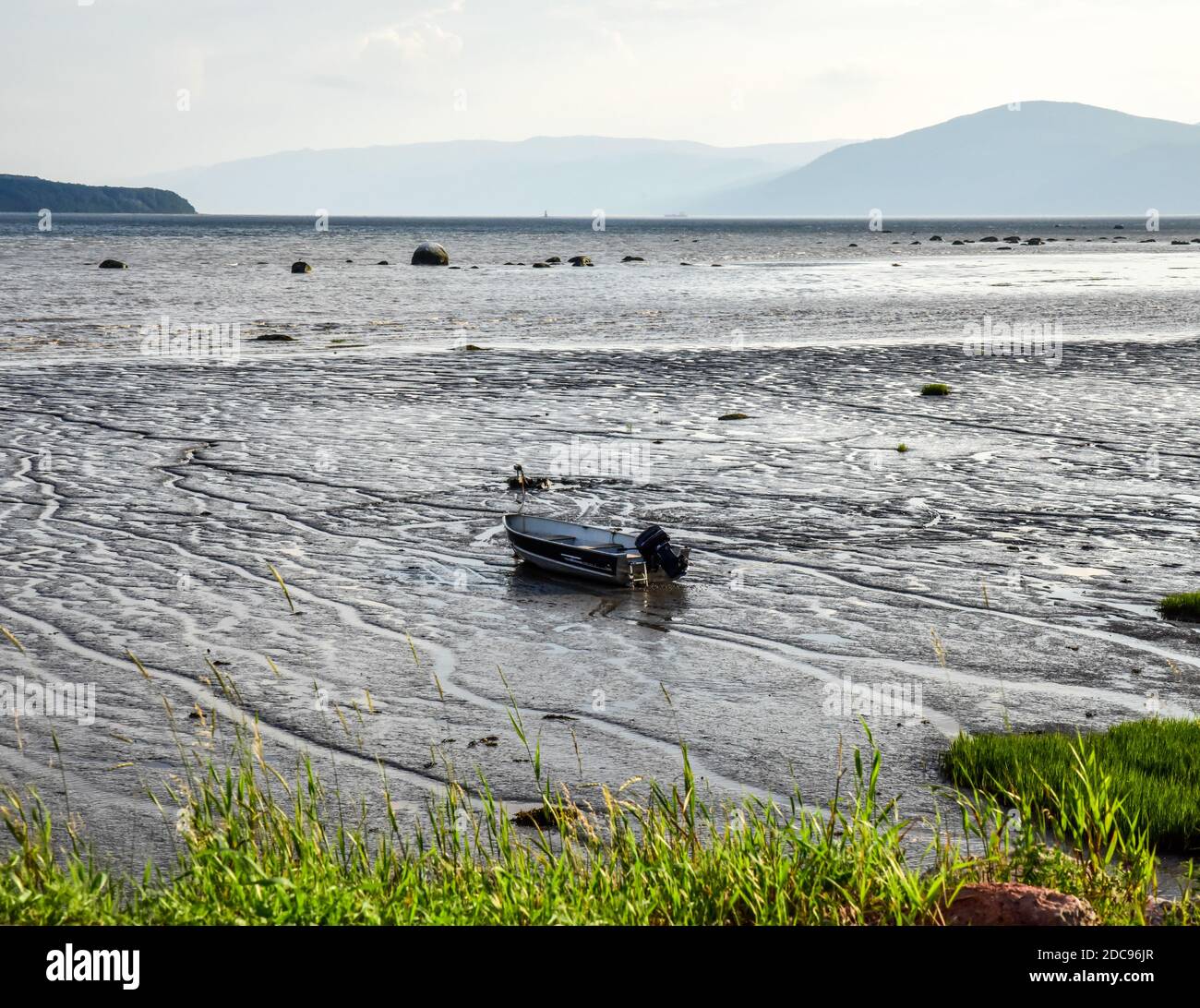 Fishing boat beached at low tide along the ocean harbor Stock Photo - Alamy