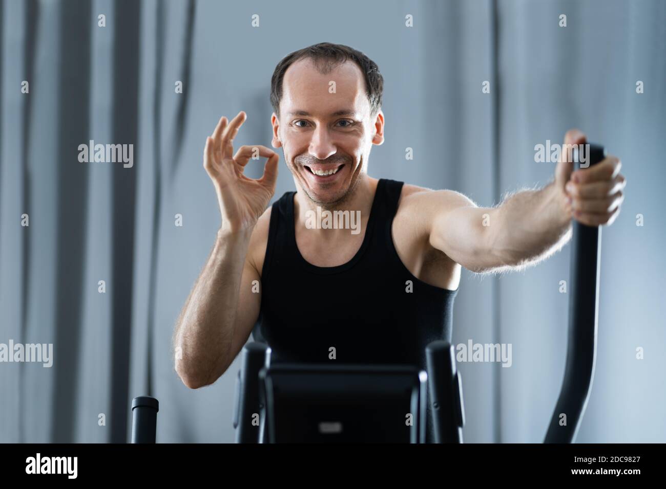 Man Training On Elliptical Trainer At Home Stock Photo