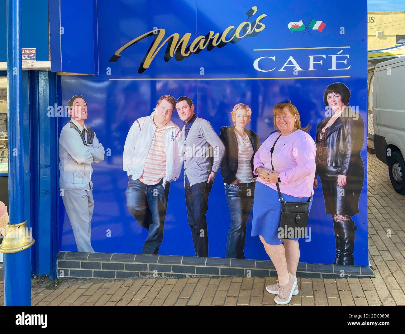 Tourist by Marco's Cafe sign (featured in 'Gavin & Stacey' sitcom), Barry Island, Barry, Vale of Glamorgan, Wales (Cymru), United Kingdom Stock Photo
