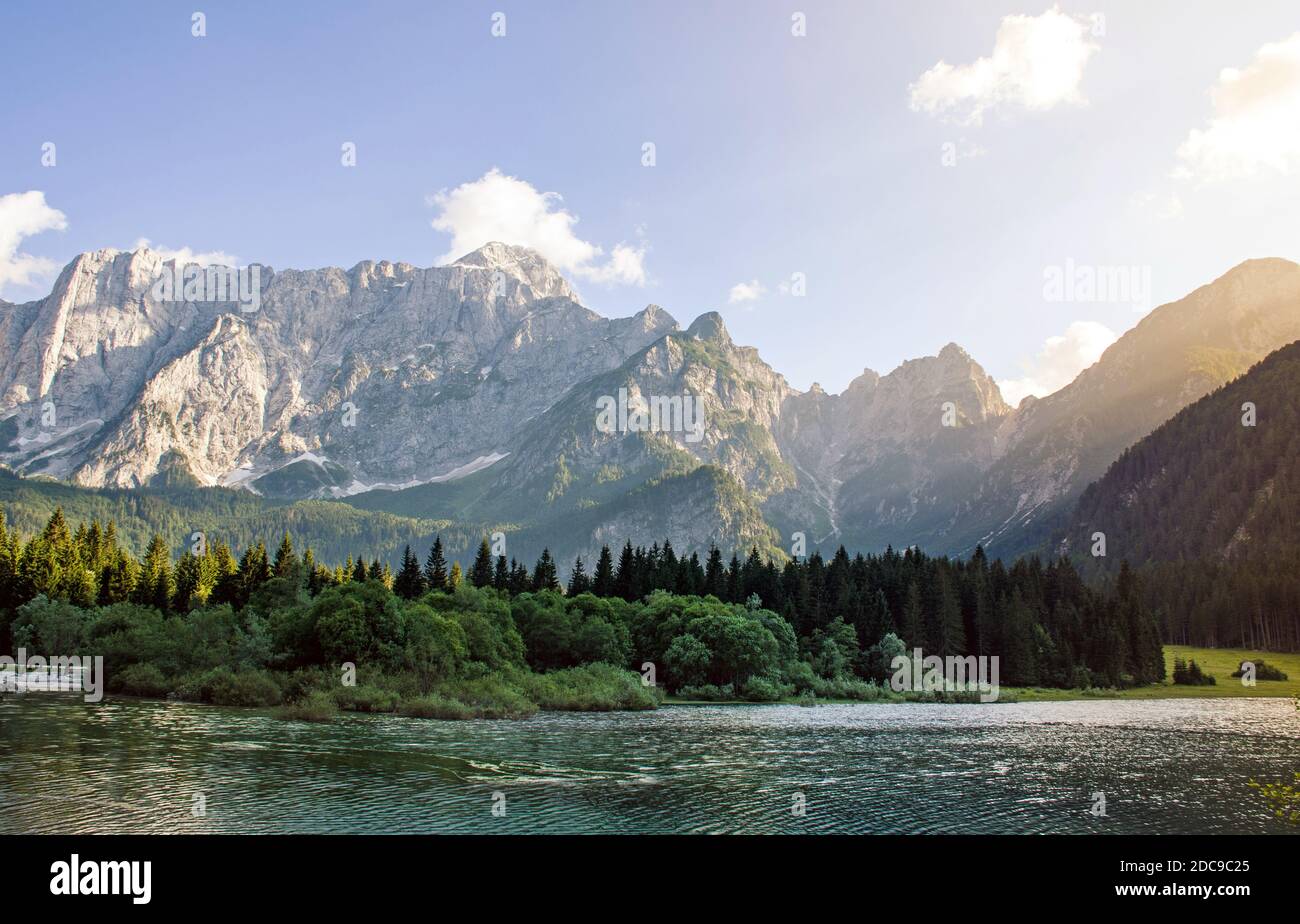 A beautiful view of a lake surrounded by rocky mountains and greenery ...
