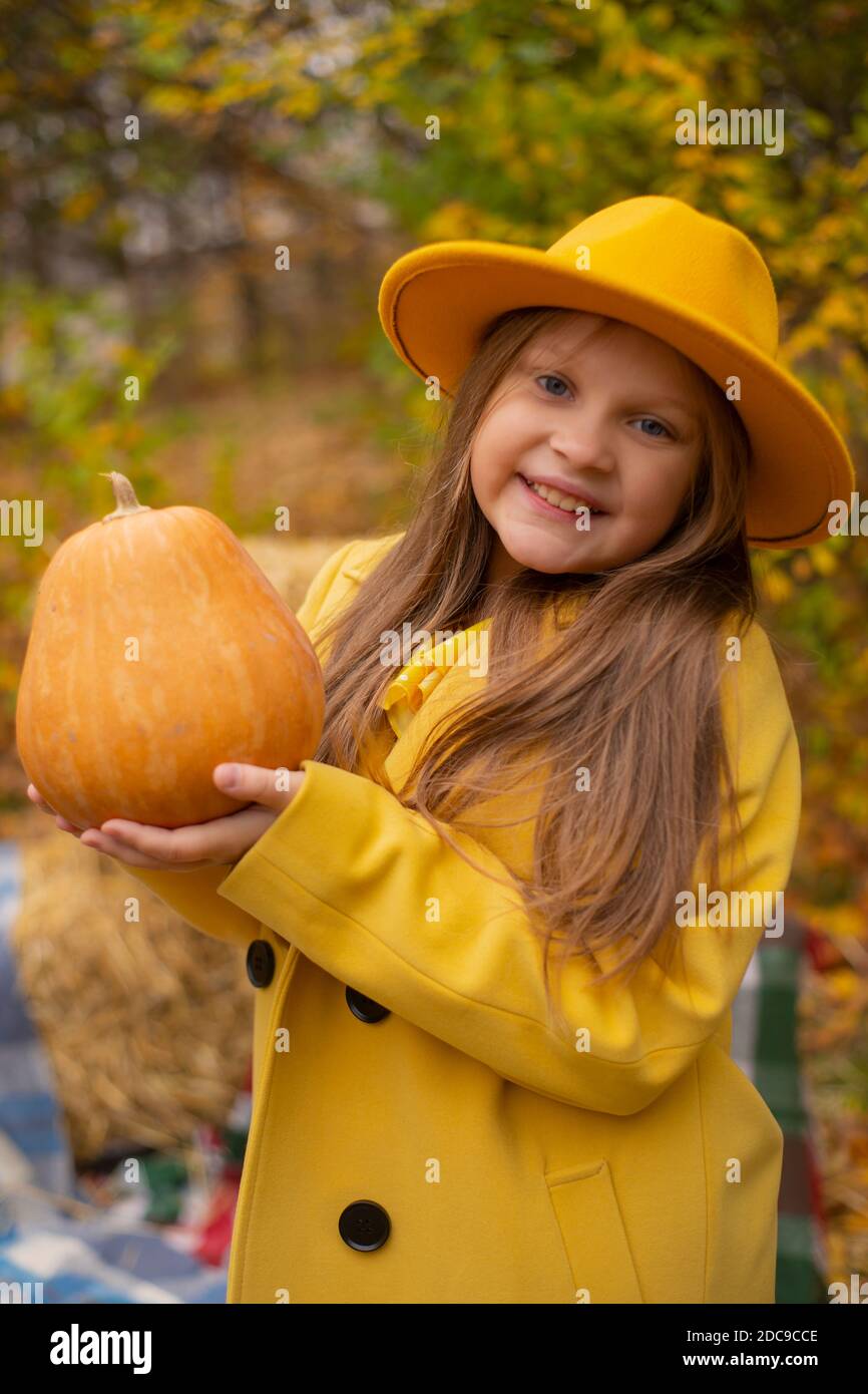 cute beautiful teenage brunette girl in an orange hat, dress and coat ...