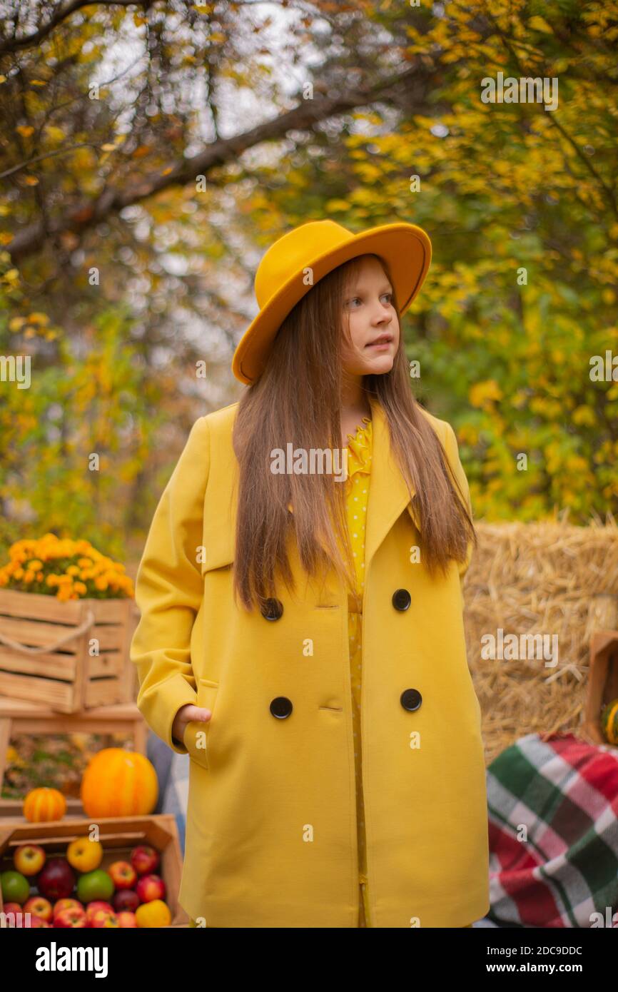 cute beautiful teenage brunette girl in an orange hat, dress and coat ...