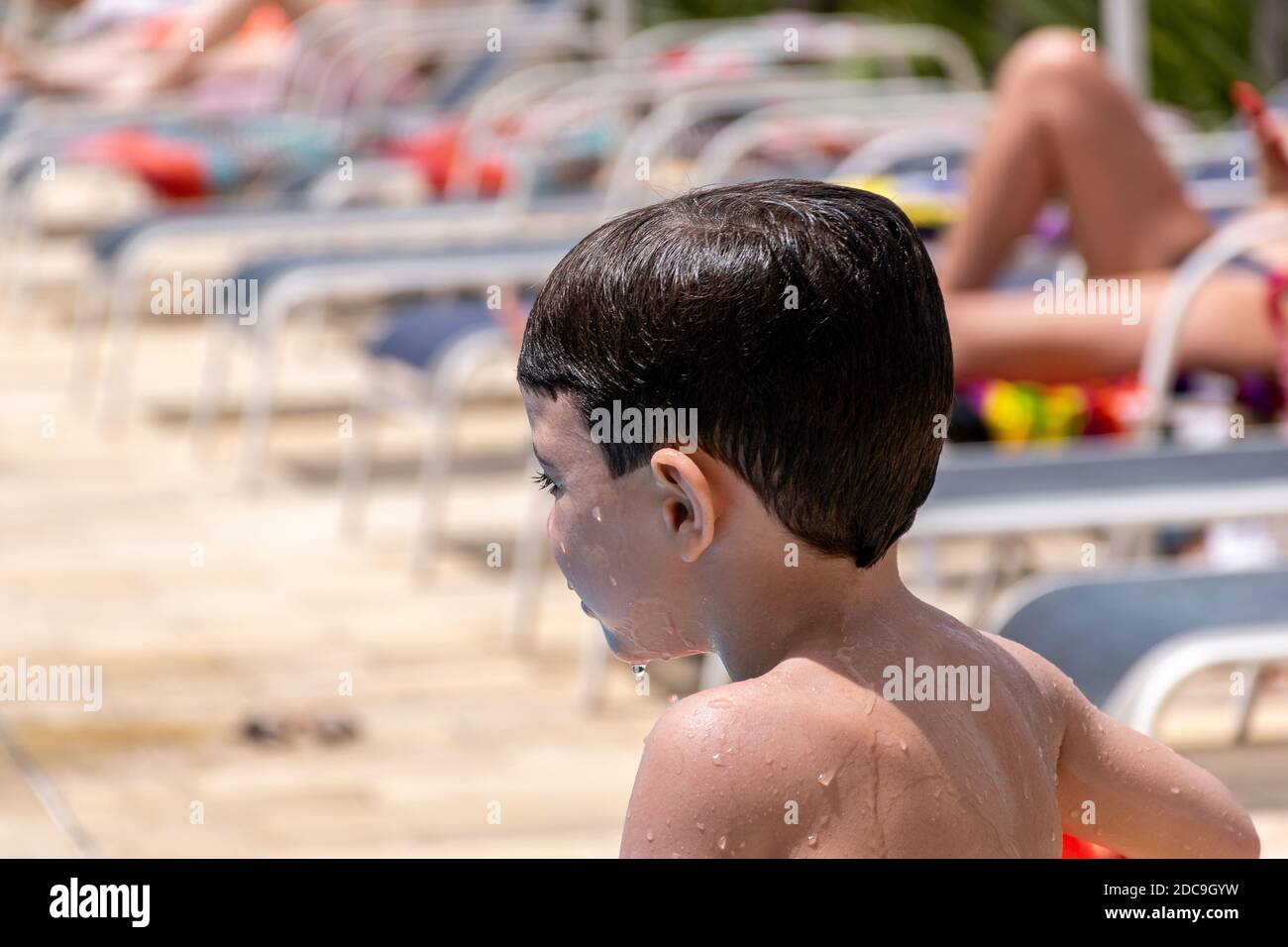 Side views of a wet child looking at the pool. Stock Photo