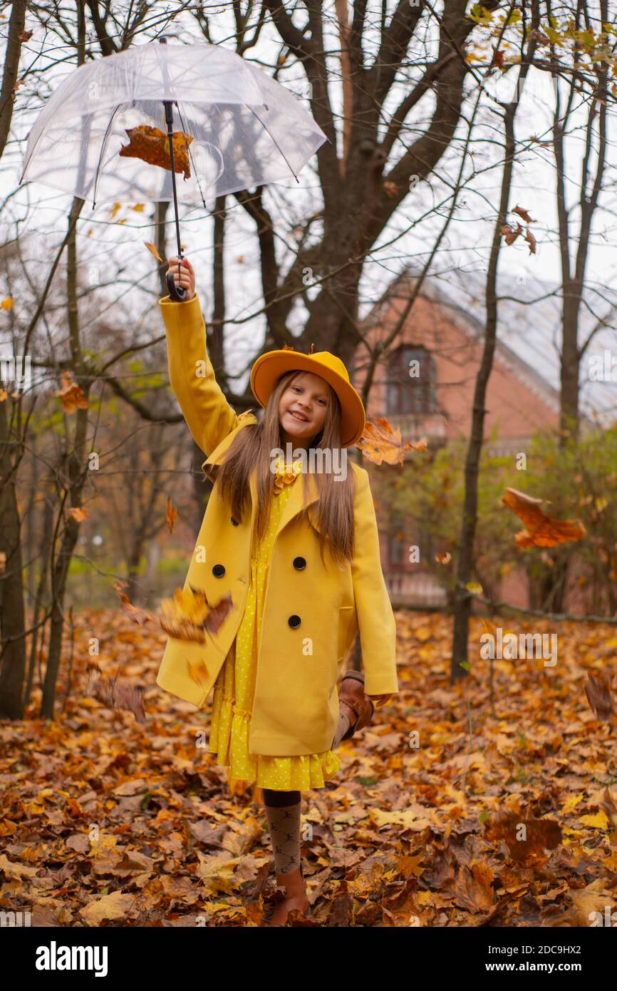 cute beautiful teenage brunette girl in an orange hat, dress and coat ...