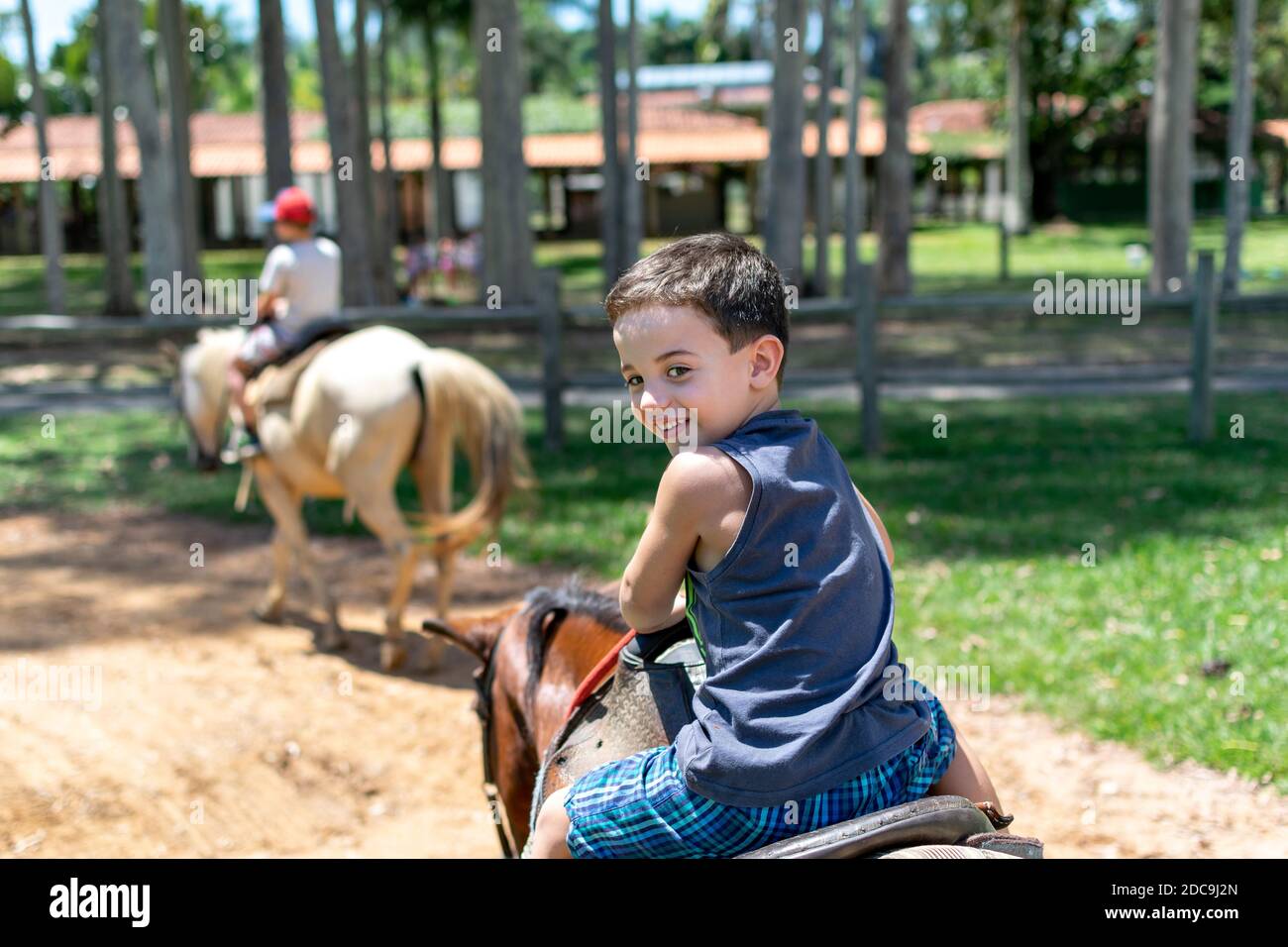 5 year old boy doing a horse ride and looking back Stock Photo - Alamy