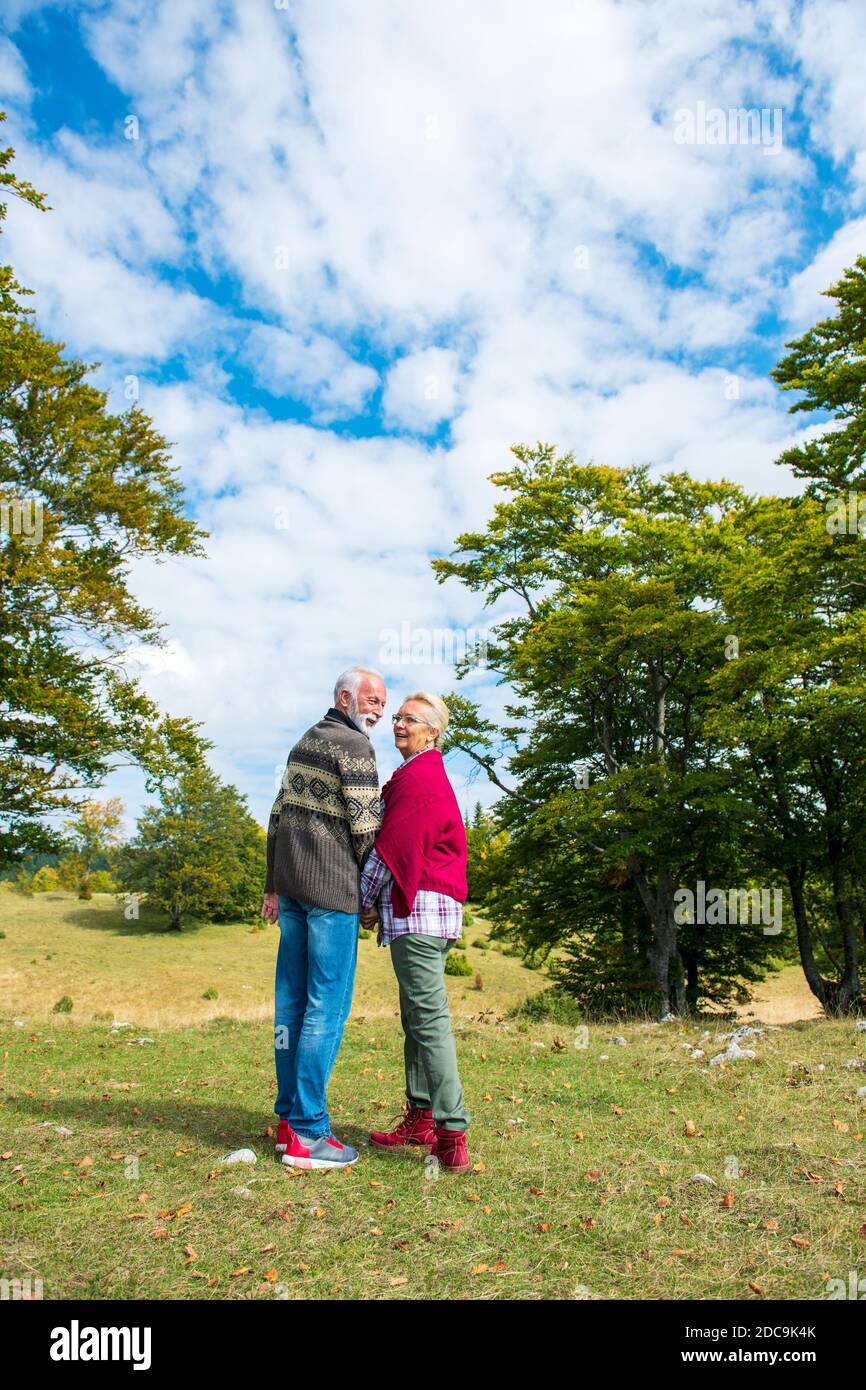 Senior couple on a walk in an autumn nature Stock Photo - Alamy