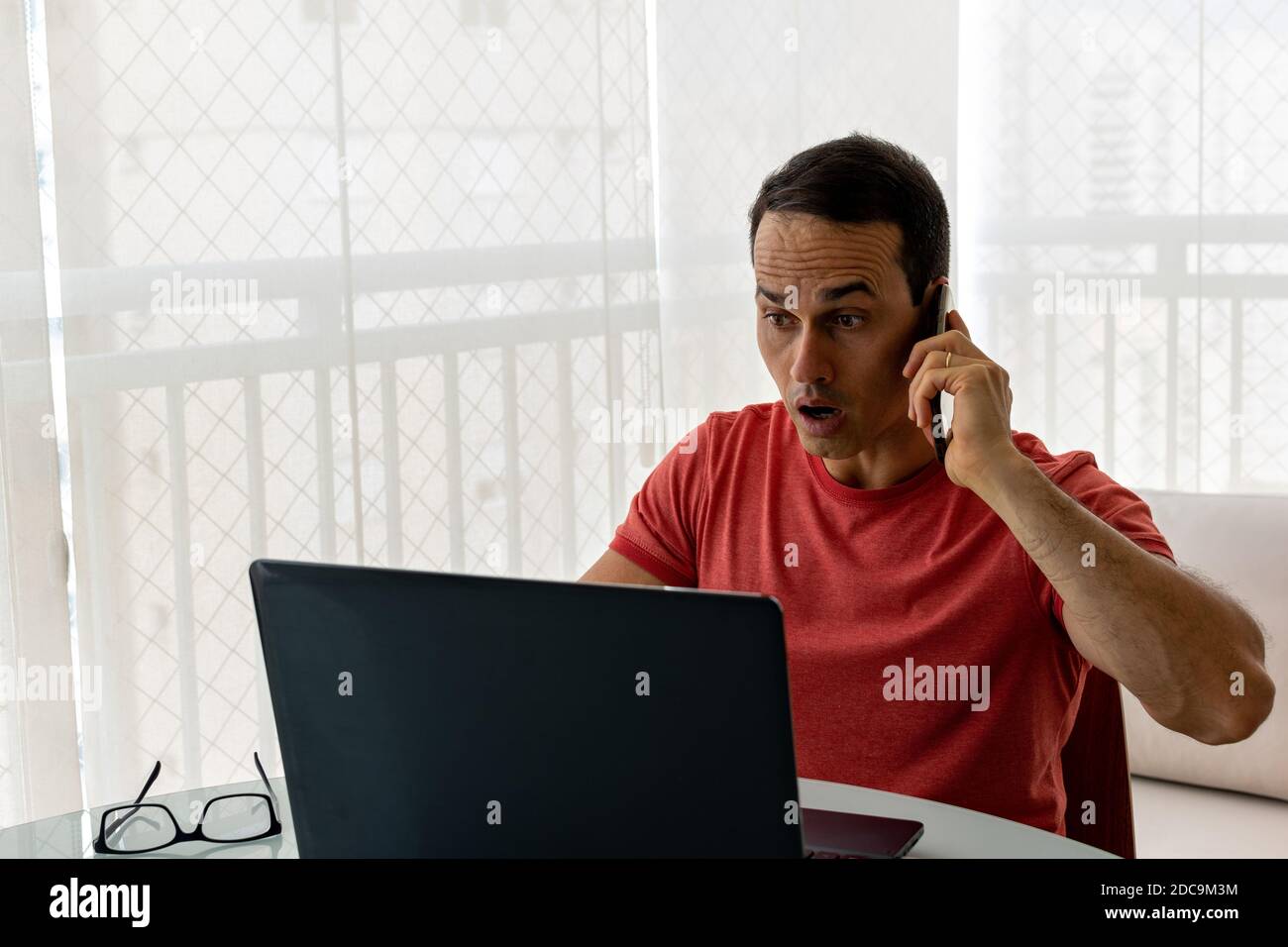 Mature man working at home and looking scared for the laptop. Stock Photo