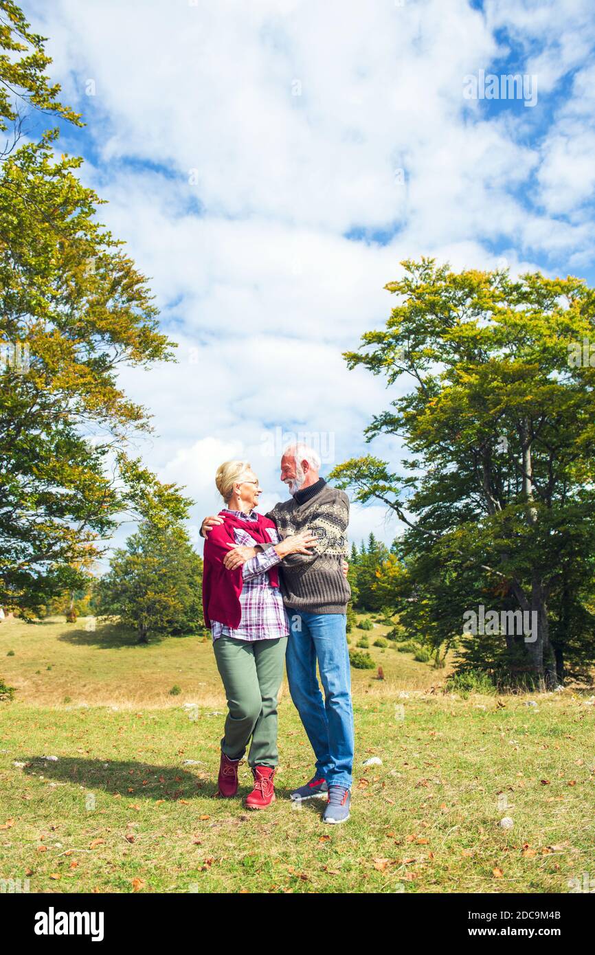 Senior couple on a walk in an autumn nature Stock Photo - Alamy