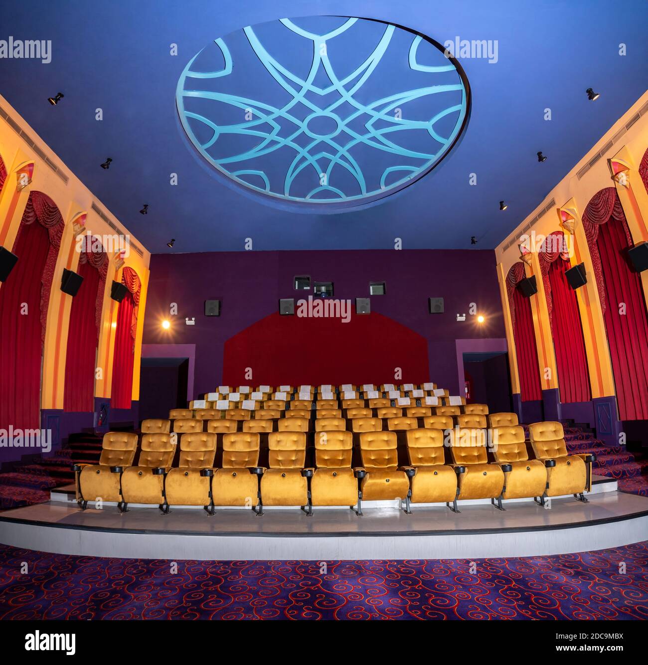 Large cinema theater interior with seat rows for audience to sit in
