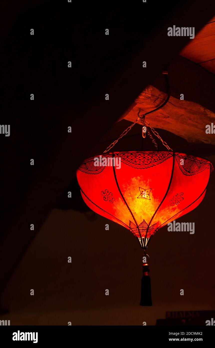 Chinese styled lamp illuminated haning from old wooden ceiling Stock Photo