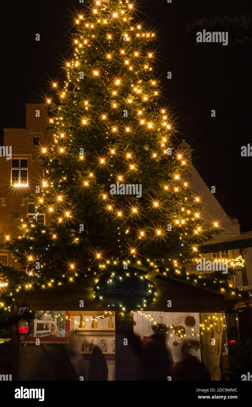 illuminated christmas tree at german christmas market with sales booth