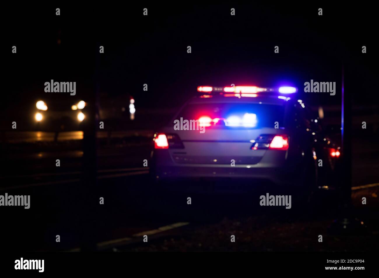 Blurred police emergency flash lights at night from the back on highway Stock Photo