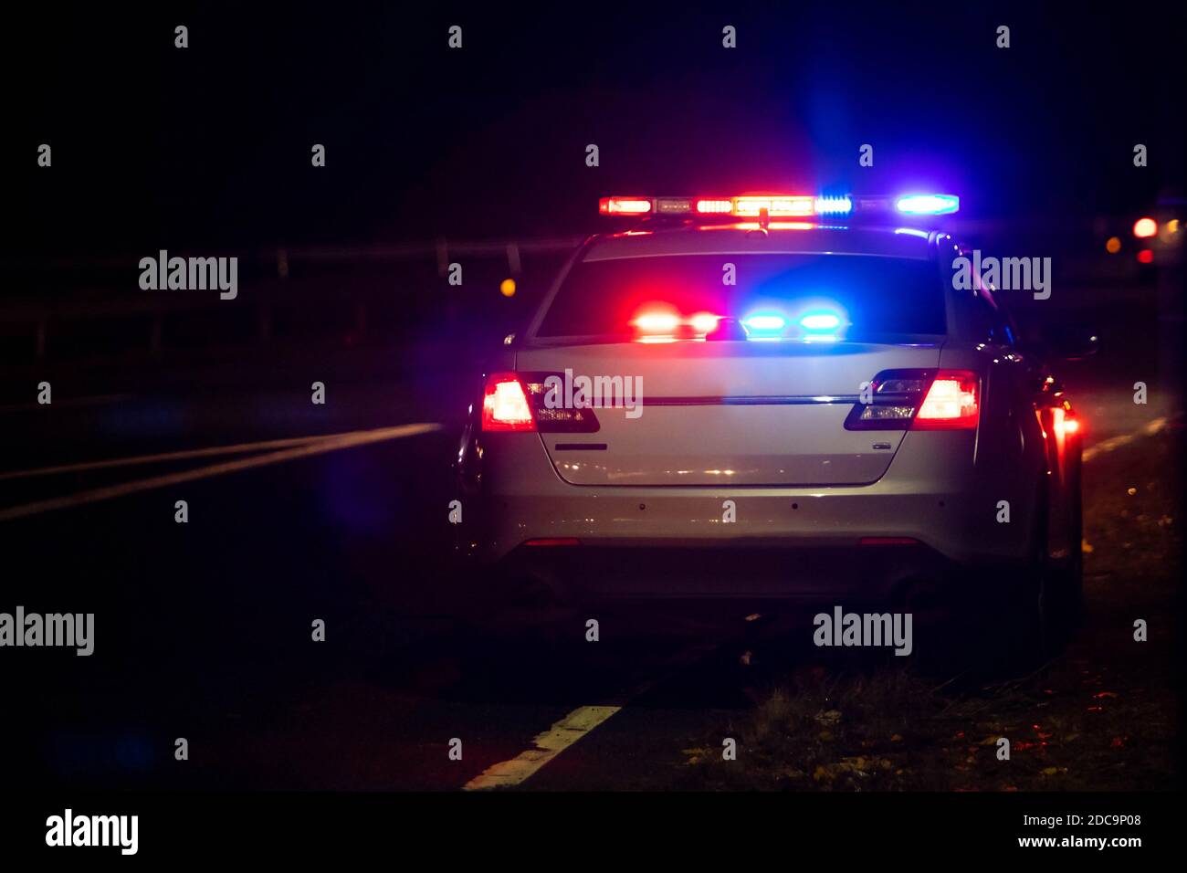 Police emergency flash lights at night from the back on highway Stock Photo