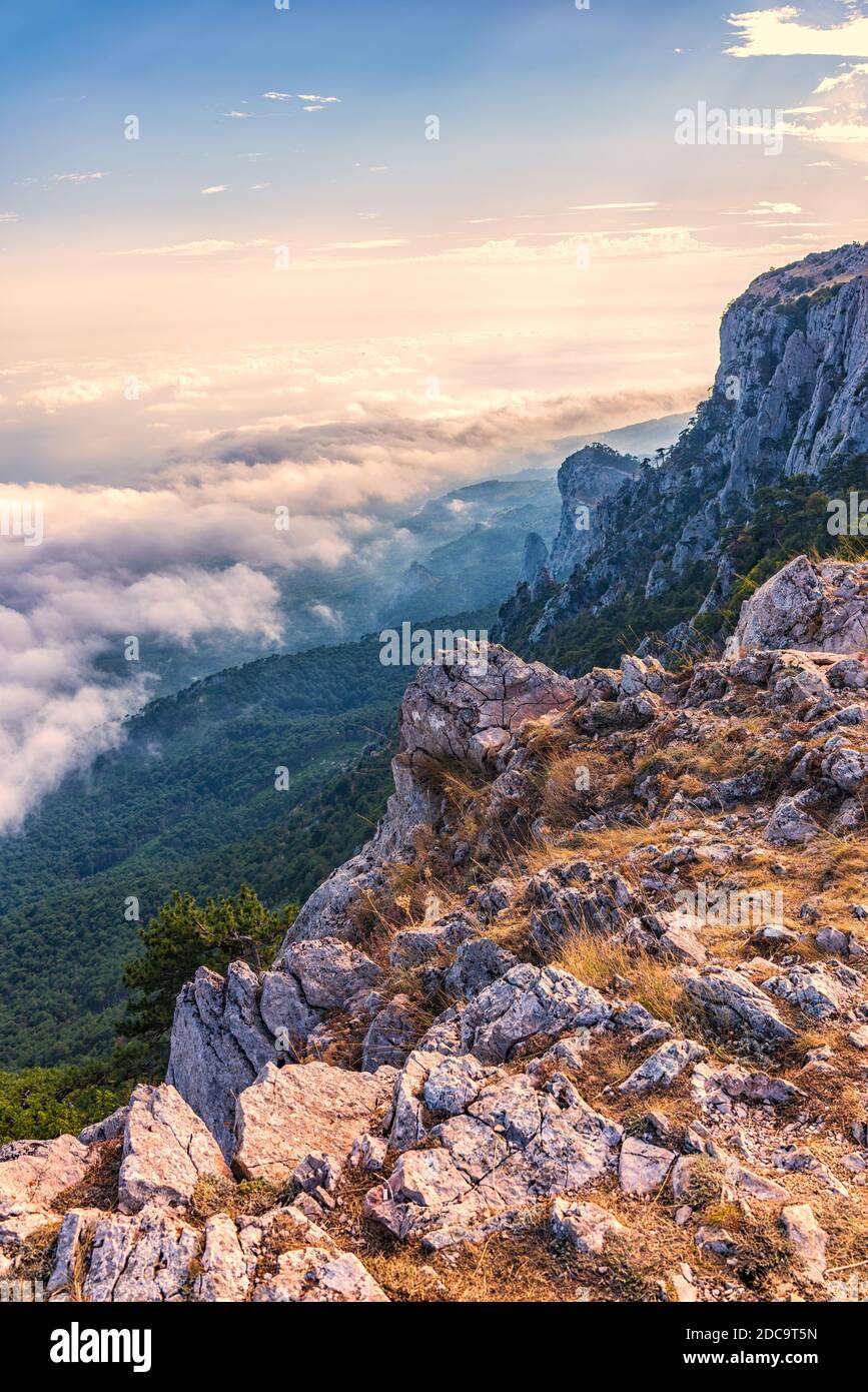 A majestic view of the rocky mountains and the valley in fog and clouds ...