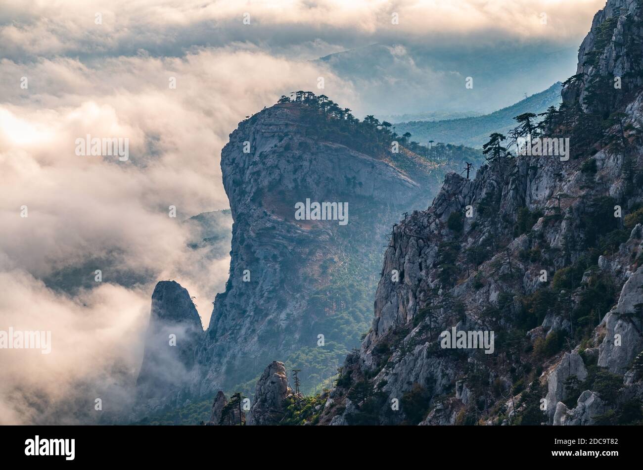 A majestic view of the rocky mountains and the valley in fog and clouds ...