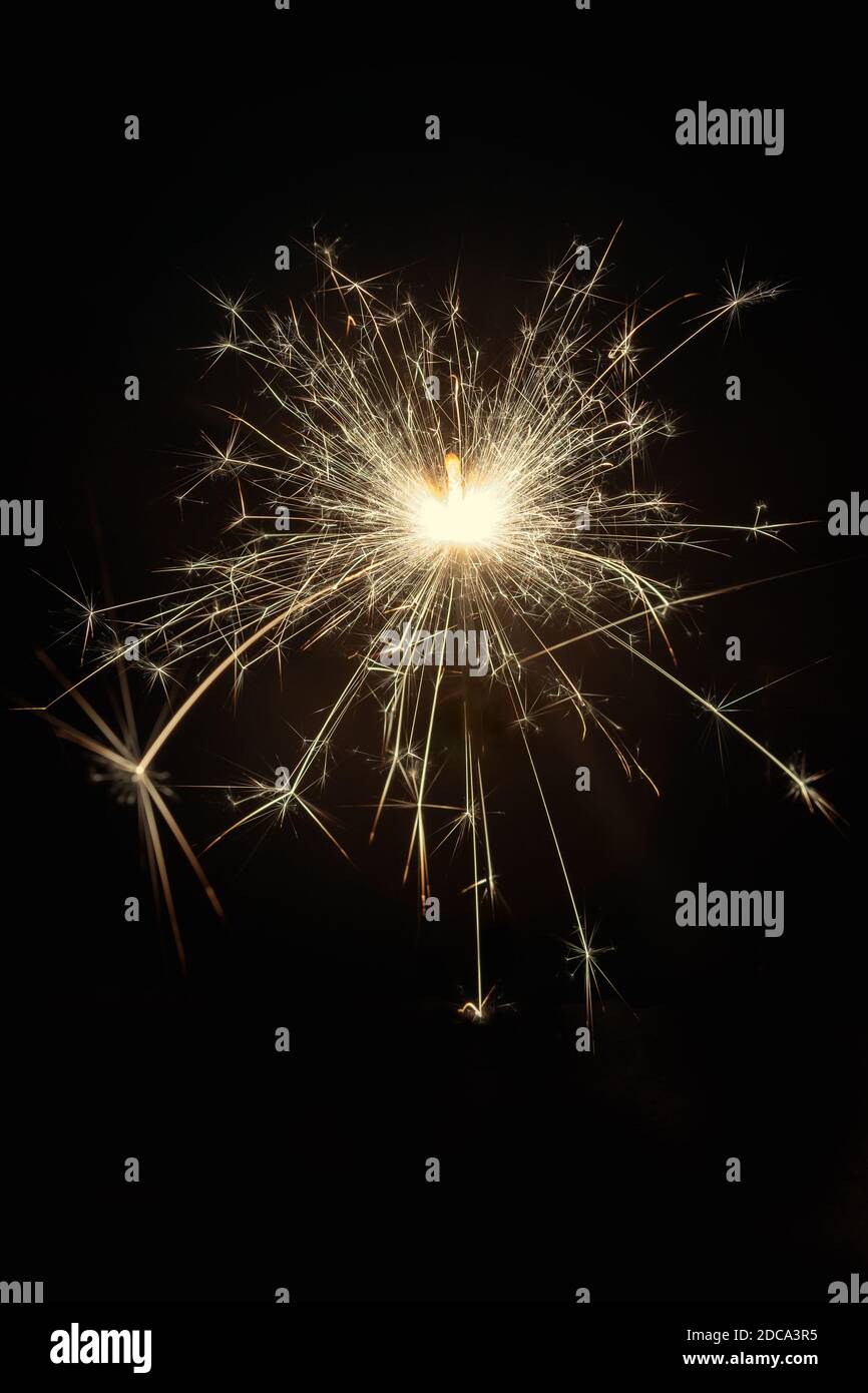 Glittering burning sparkler on black background Stock Photo