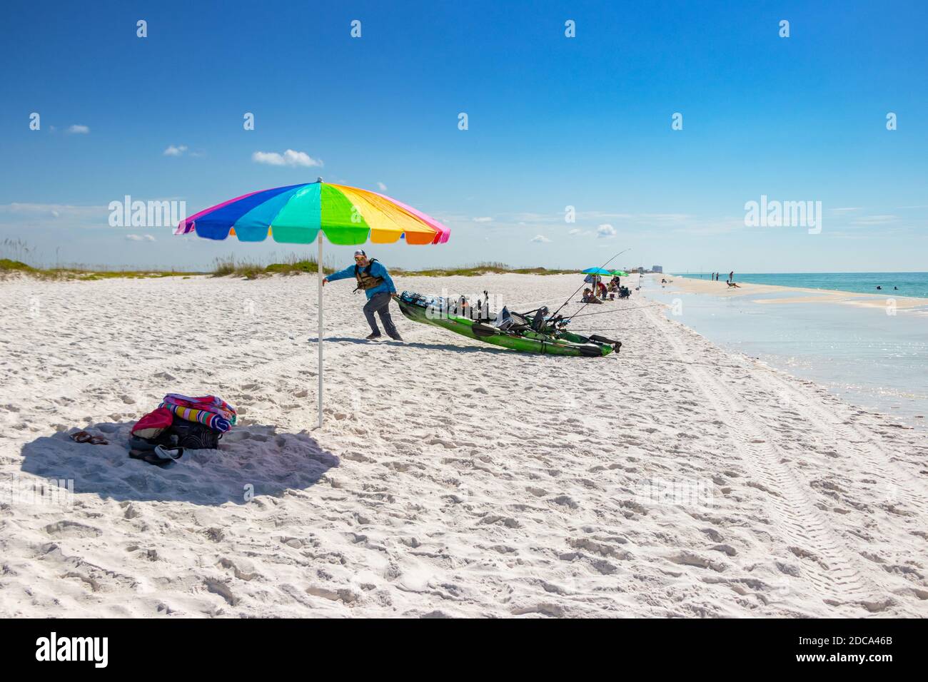 isolated colourful rainbow sun parasol shade with sand and sea at beach at Biloxi Mississippi USA Stock Photo