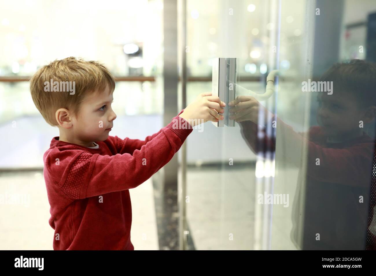 Portrait of boy calling elevator in mall Stock Photo Alamy