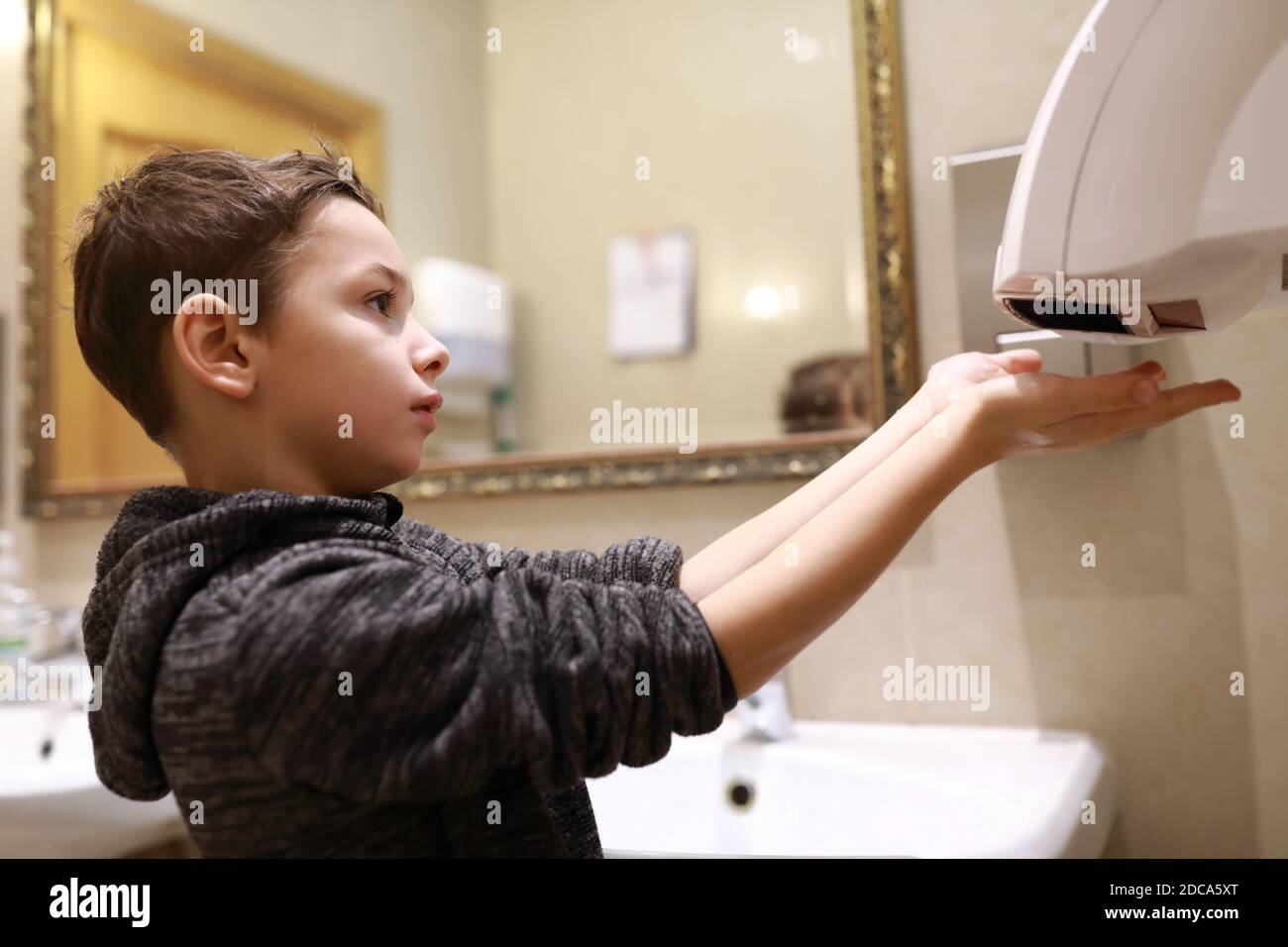 Boy drying his hands in a restroom Stock Photo Alamy