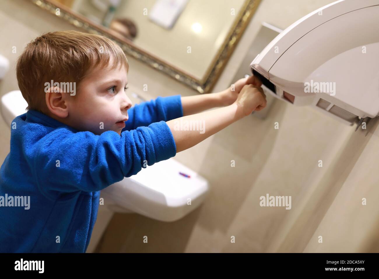 Child drying his hands in a restroom Stock Photo Alamy
