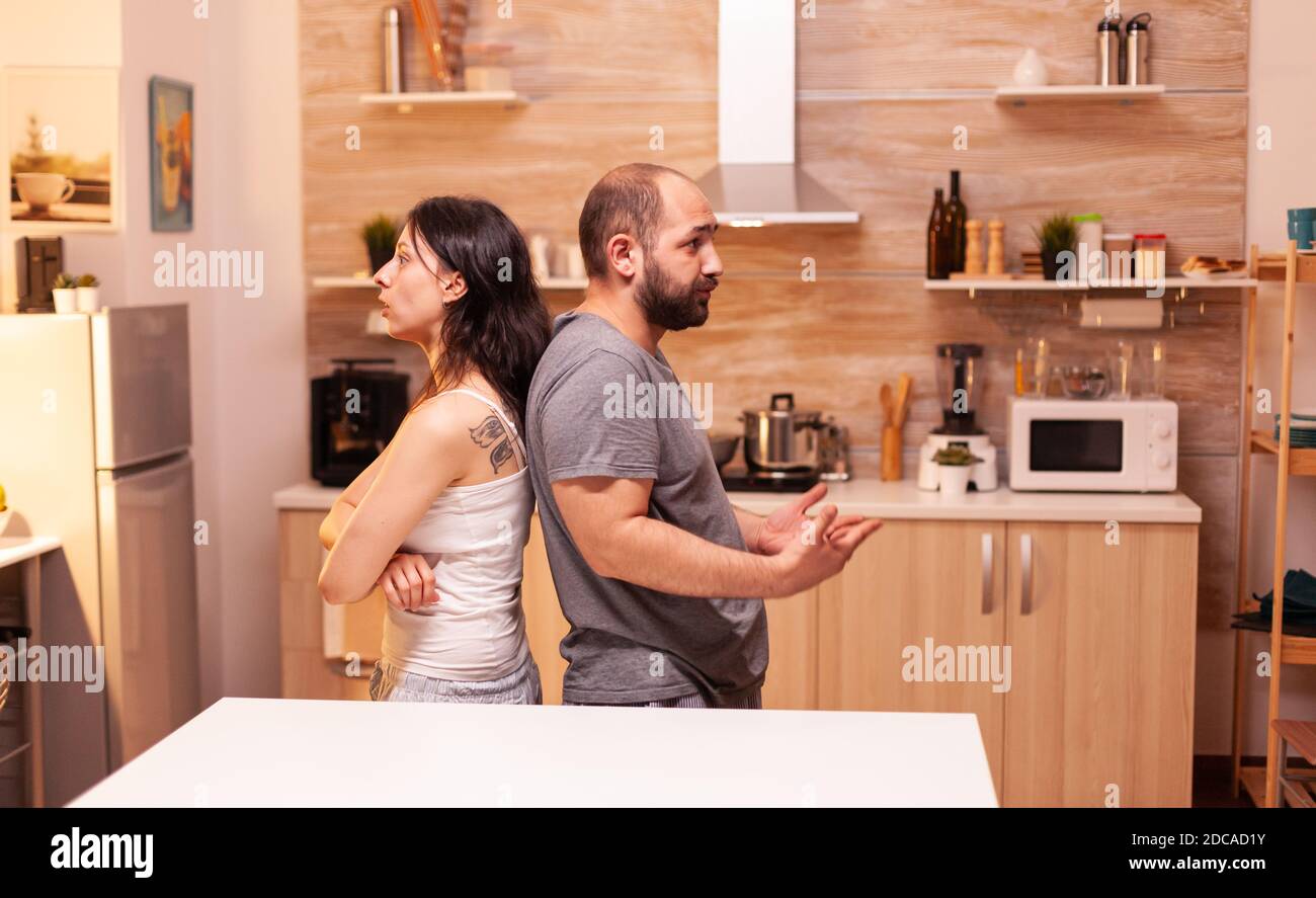 Disappointed husband suspecting wife of infidelity while having a relationship disagreement. Frustrated offended irritated accusing woman of infidelity arguing her. Stock Photo