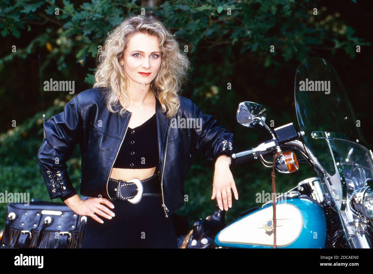 Schlagersängerin Nicole posiert neben einem Harley Davidson Motorrad, Deutschland um 1994. Stock Photo