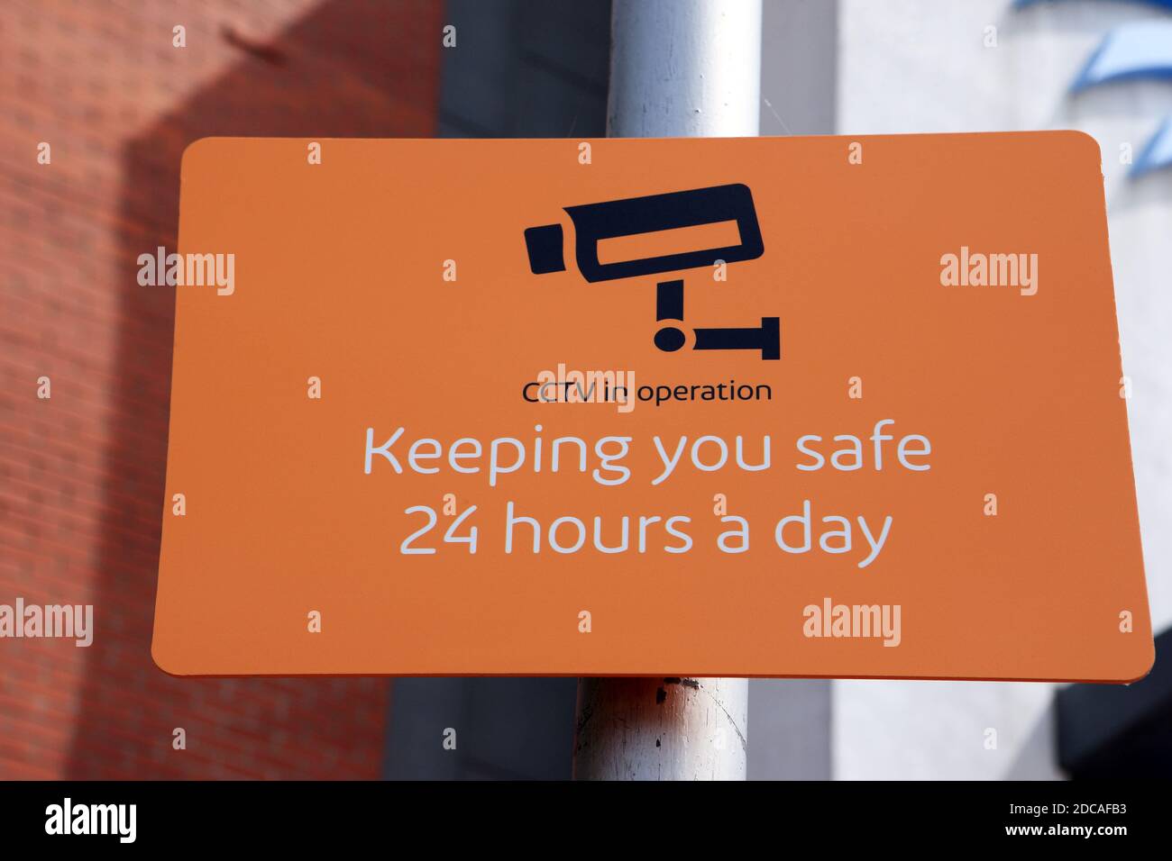 Security camera sign with a 'keeping you safe 24 hours a day' message Stock Photo