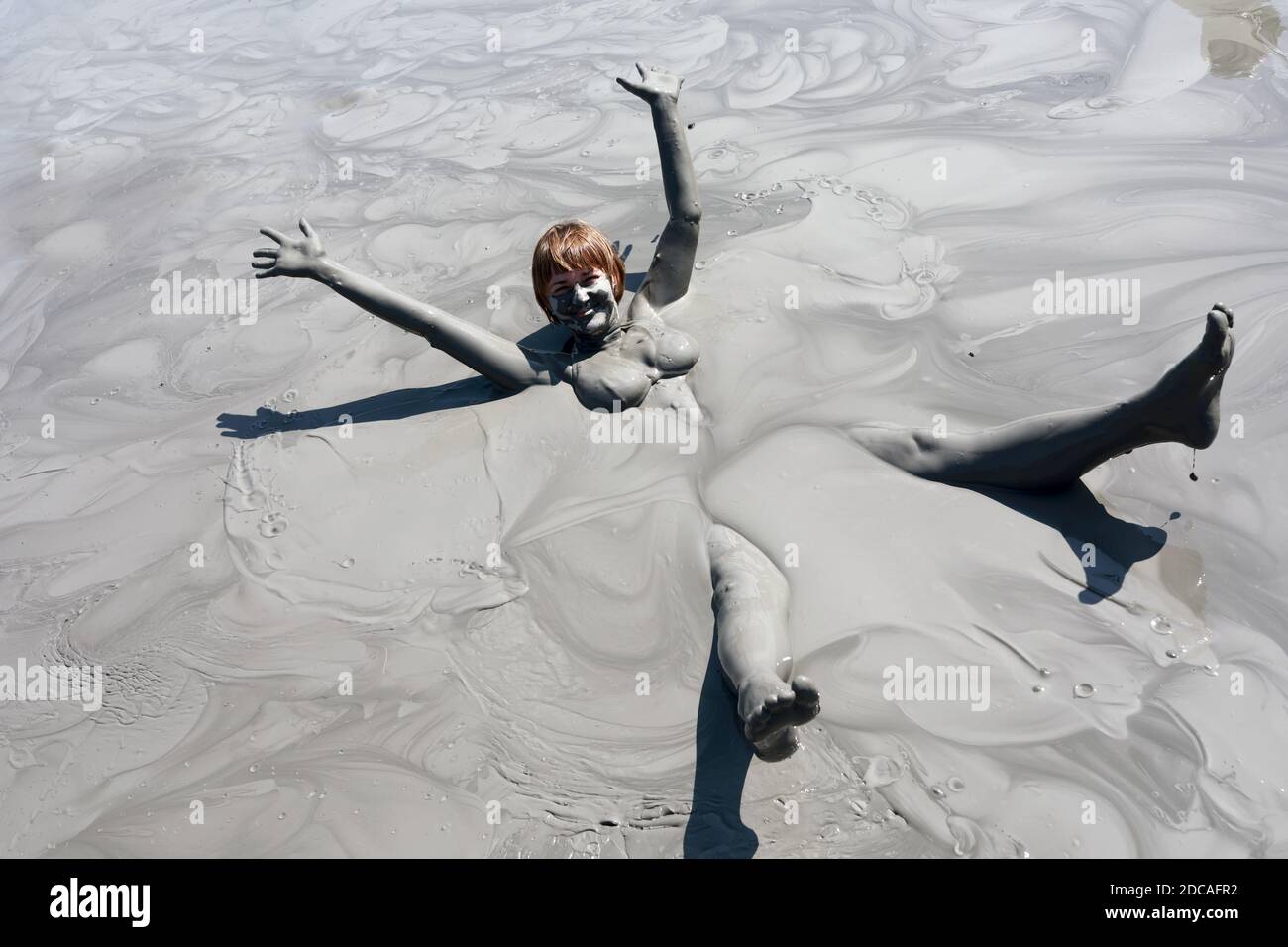 Portrait of woman lying in mud pond Stock Photo Alamy