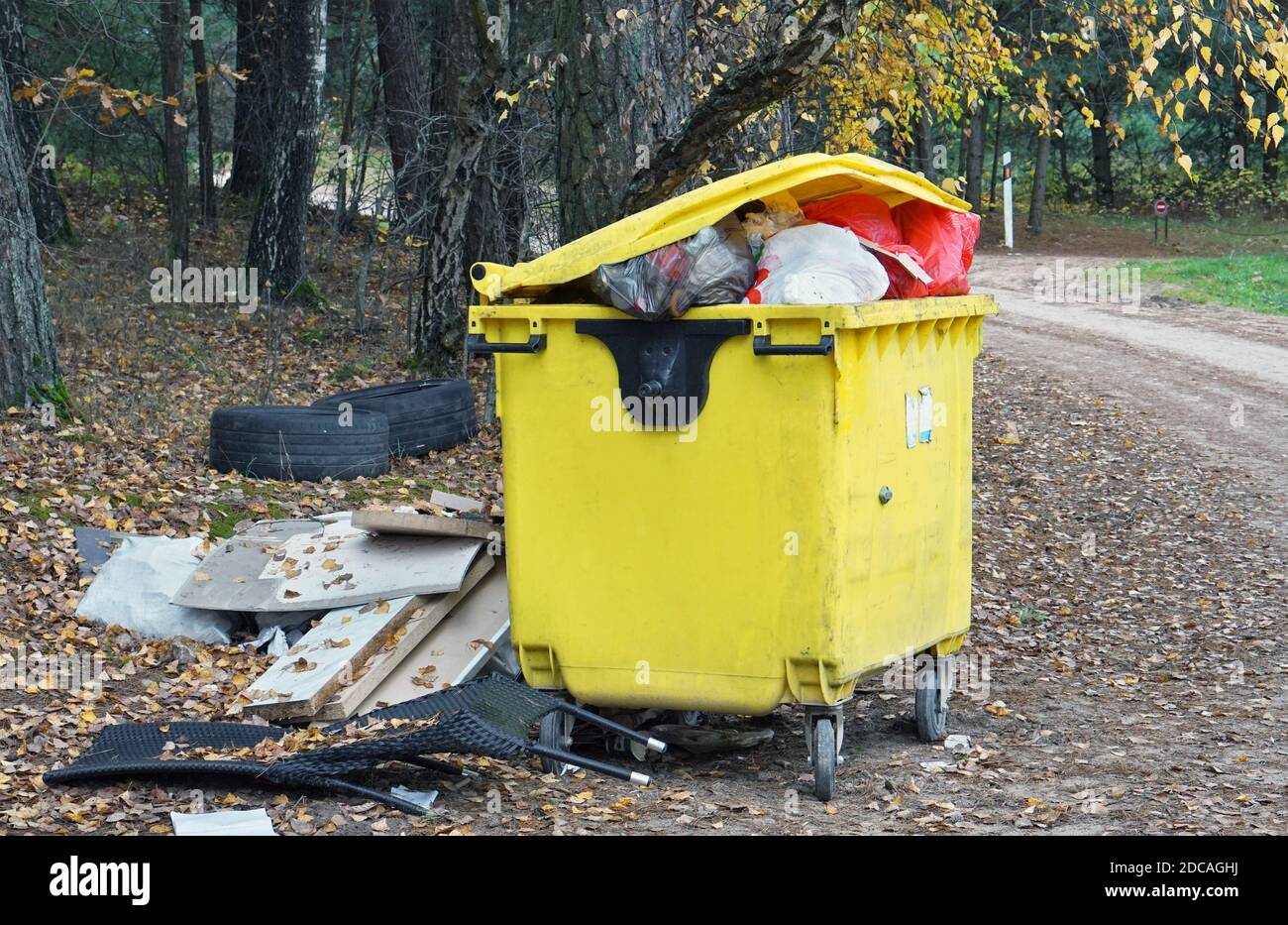 Garbage overflowing container in a autumn forest Stock Photo - Alamy